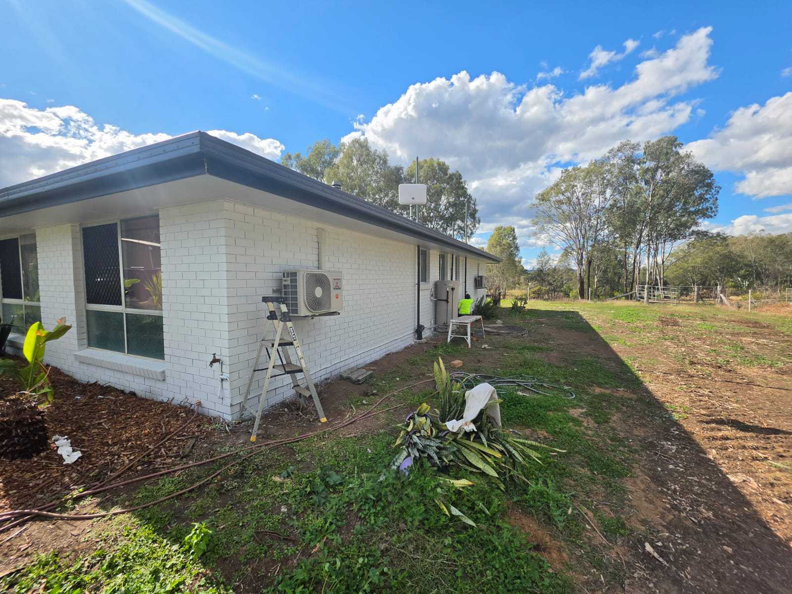 Painter applying exterior paint to a house wall